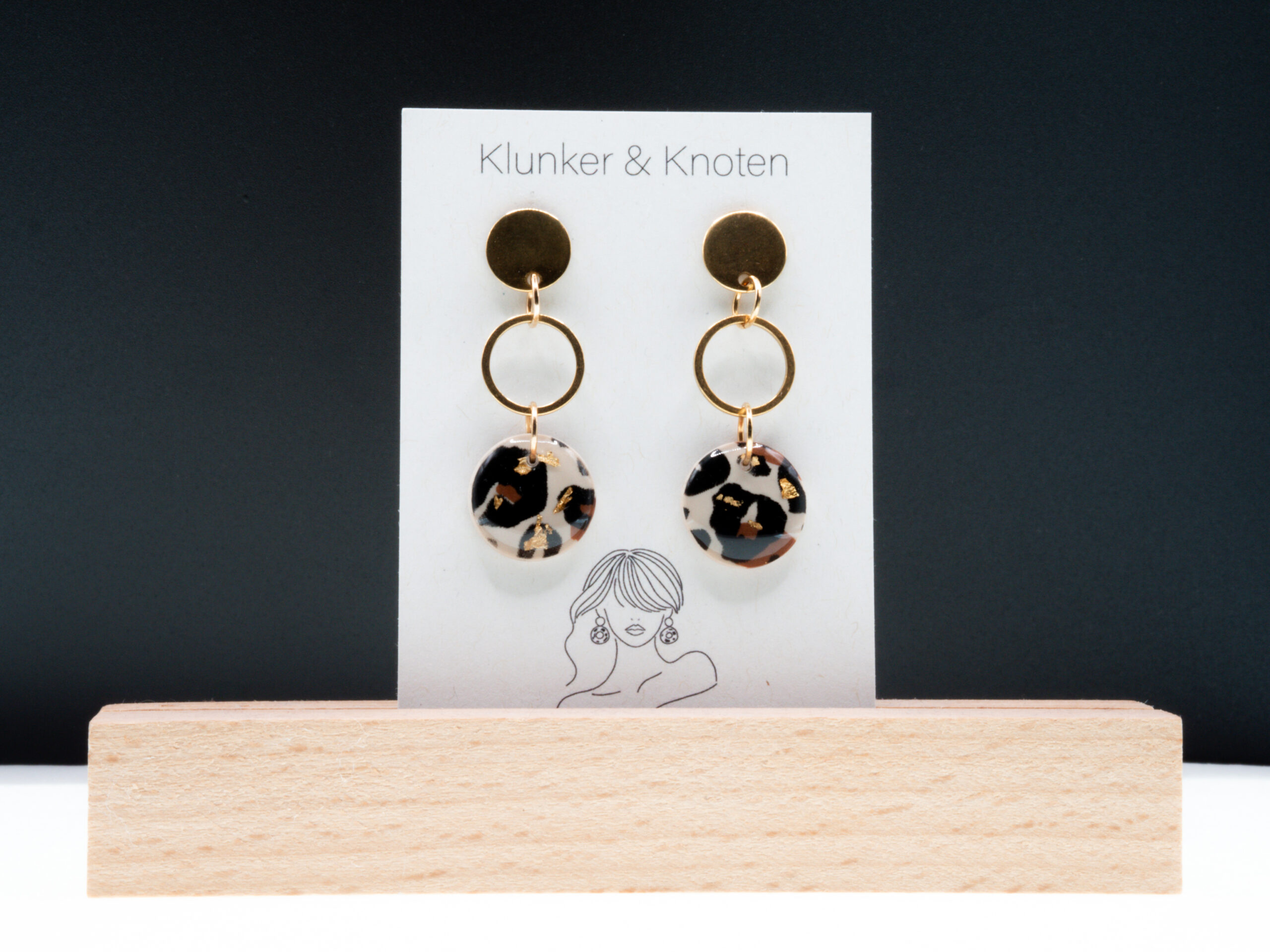 Goldfarbene Hängeohrringe aus Edelstahl mit einem runden Anhänger mit Leo-Muster