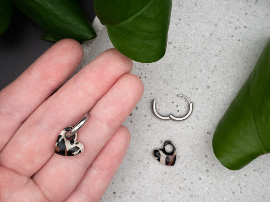 Silberfarbene Creolen mit Herzanhänger im Leo-Muster