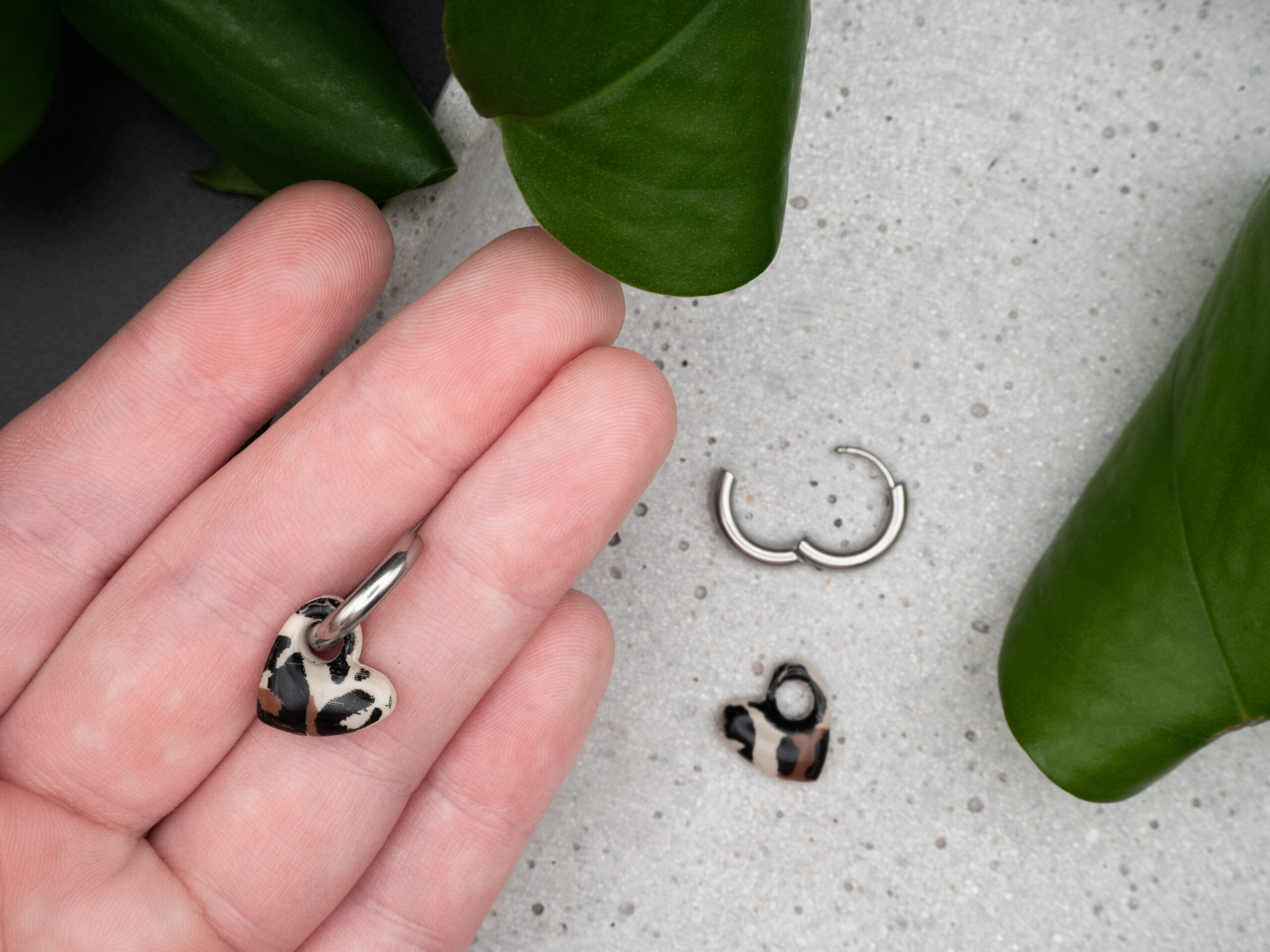 Silberfarbene Creolen mit Herzanhängern mit Leo-Muster