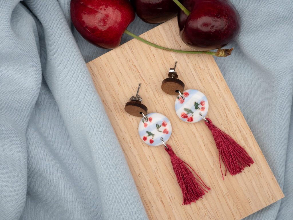 Ohrringe aus Edelstahl mit rundem Anhänger mit handbemalten Kirschen und einer Baumwoll-Quaste