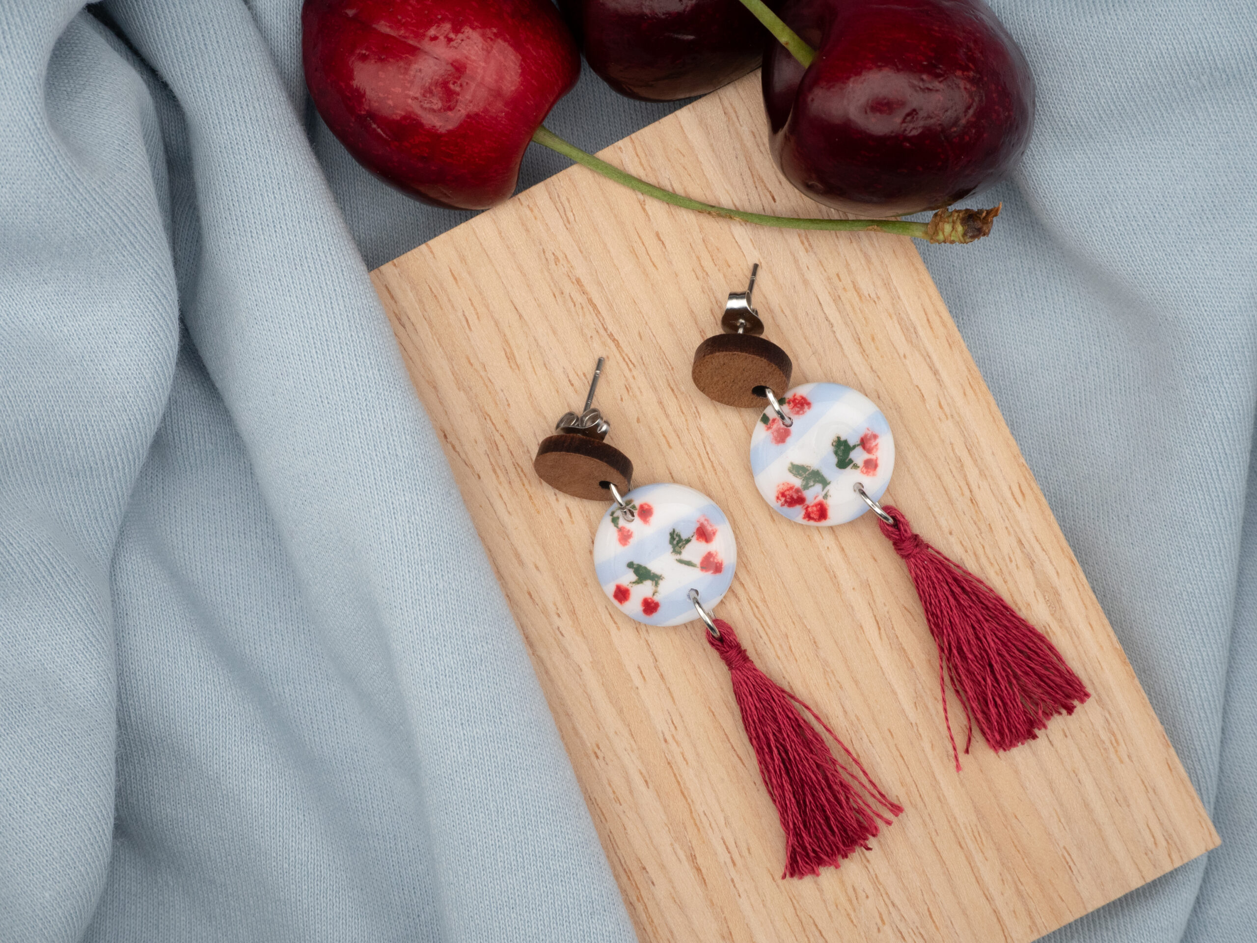 Ohrringe aus Edelstahl mit rundem Anhänger mit handbemalten Kirschen und einer Baumwoll-Quaste