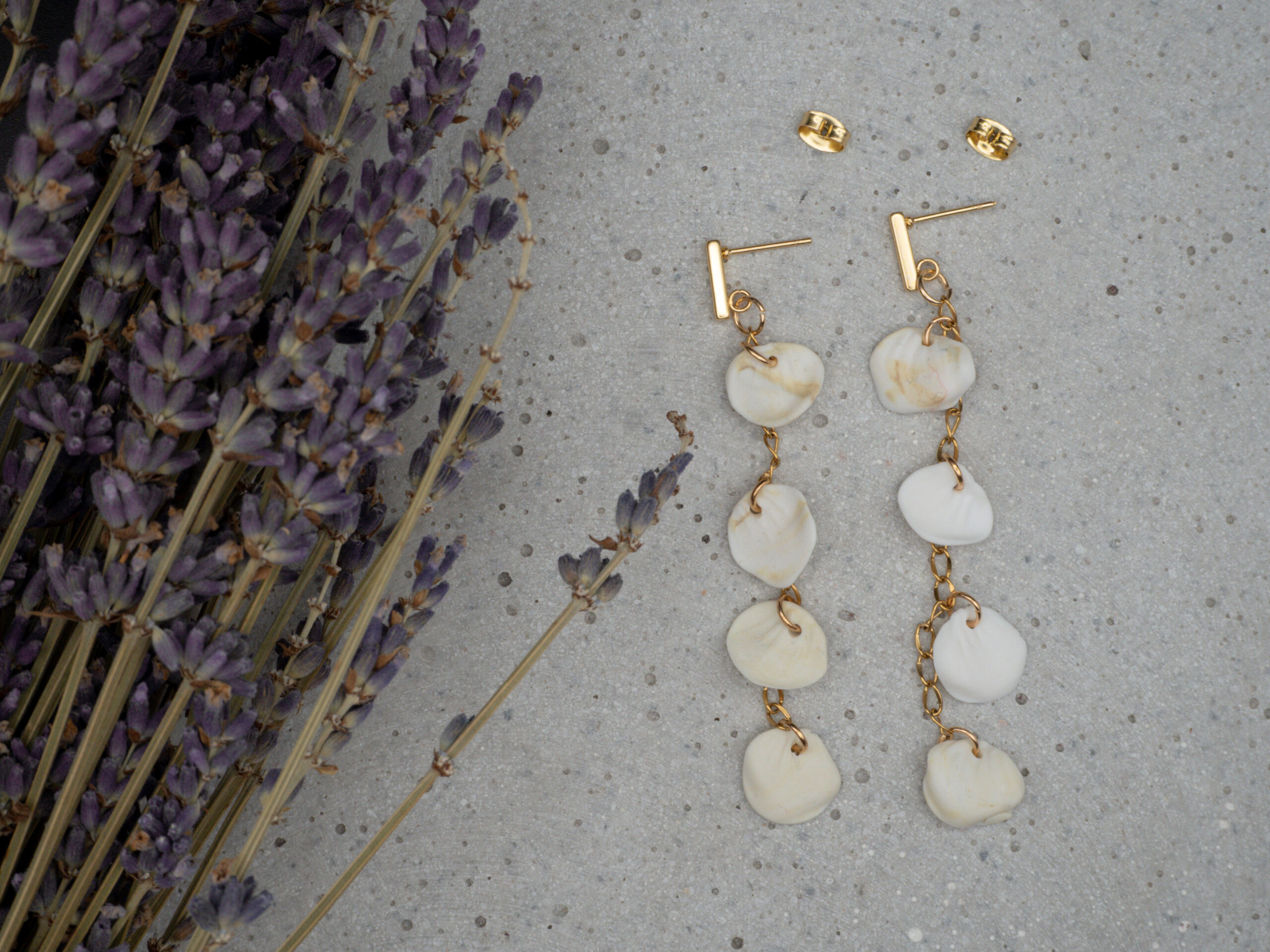 Elegante, lange goldfarbene Ohrringe aus Edelstahl mit Blütenblättern, modelliert aus Polymer Clay