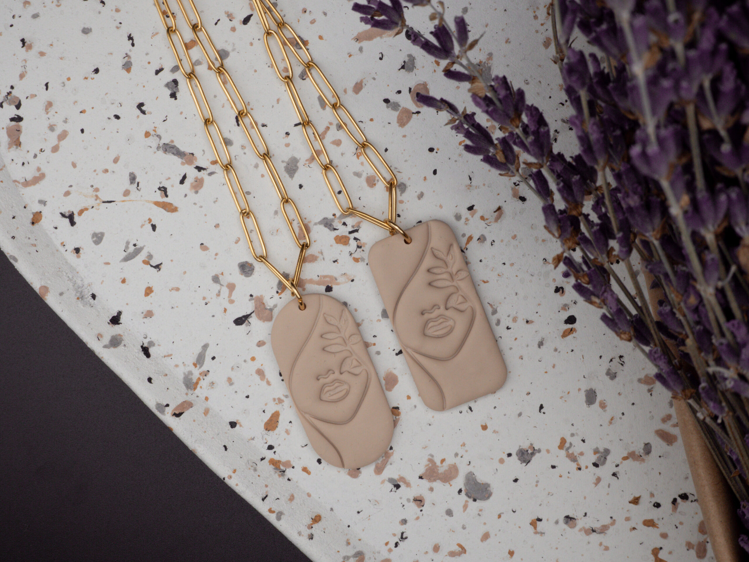 Goldfarbene Edelstahlketten mit Polymer Clay Anhängern in Beige mit Line Art Motiv in Form eines weiblichen Gesichts