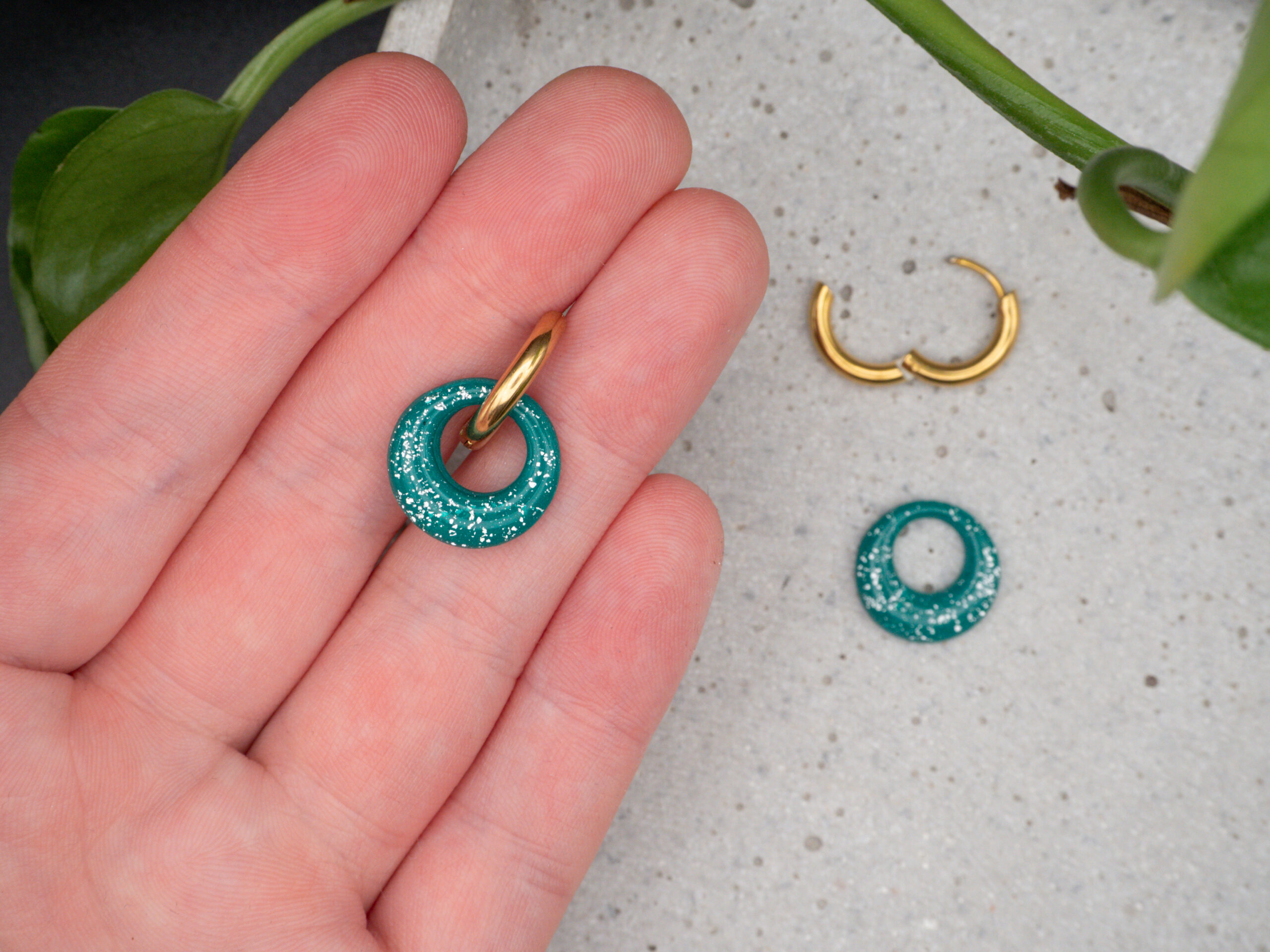 Goldfarbene Creolen aus Edelstahl mit einem kreisrunden, grünen Anhänger passend für Weihnachten