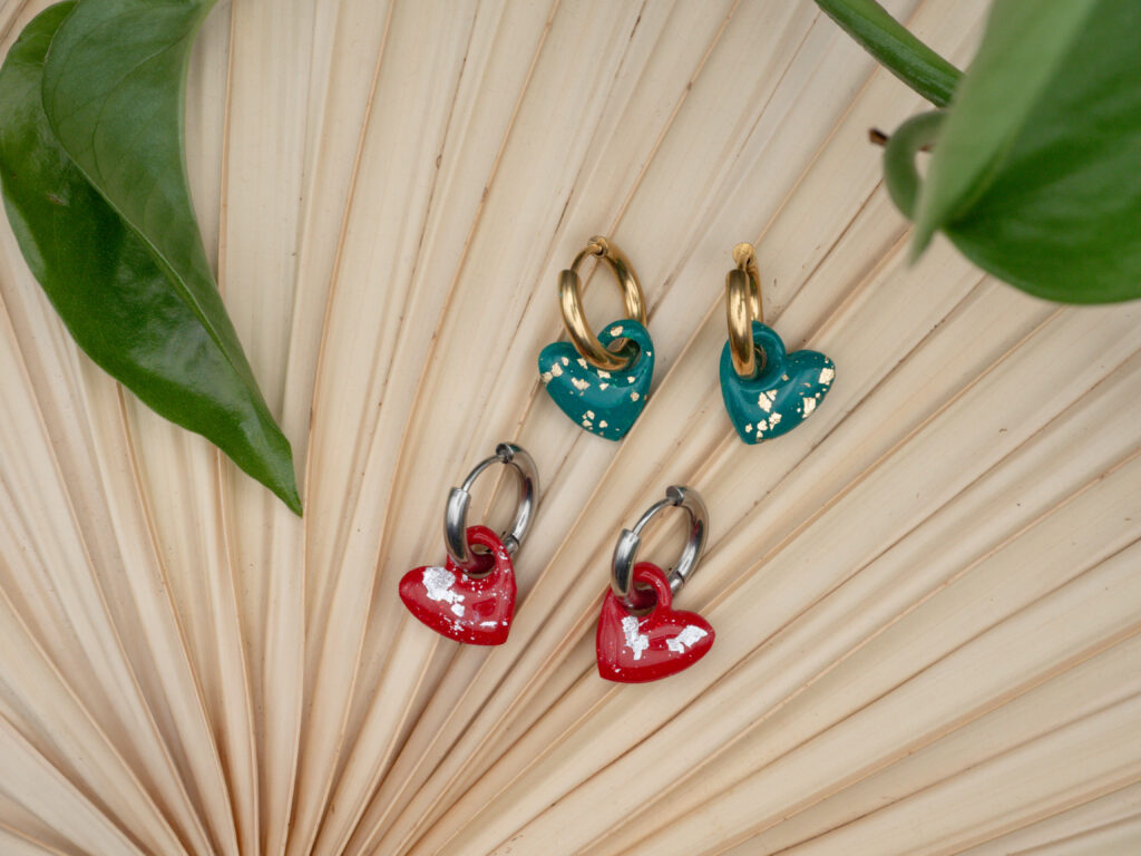 Goldfarbene und silberfarbene Creolen mit Herzanhängern in Grün und Rot mit Blattgold und -silber veredelt
